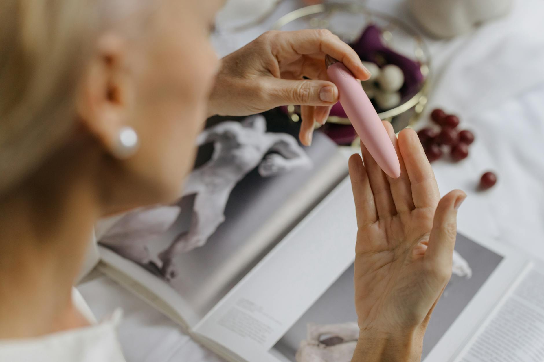 Hands exploring touch and sensation with a pink vibrator, symbolizing reconnection with the body