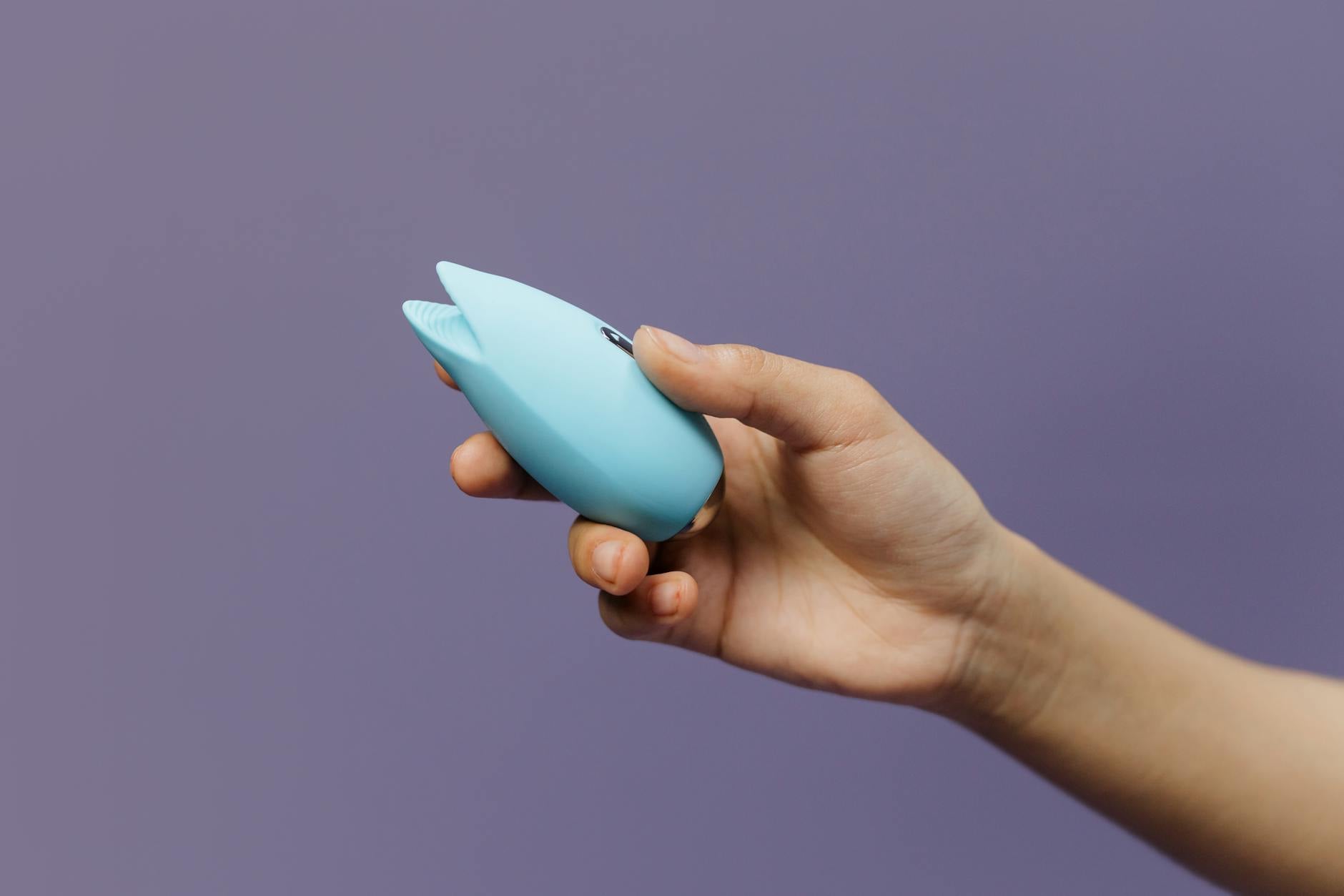 Colorful vibrators arranged on a bright yellow background in a studio setup