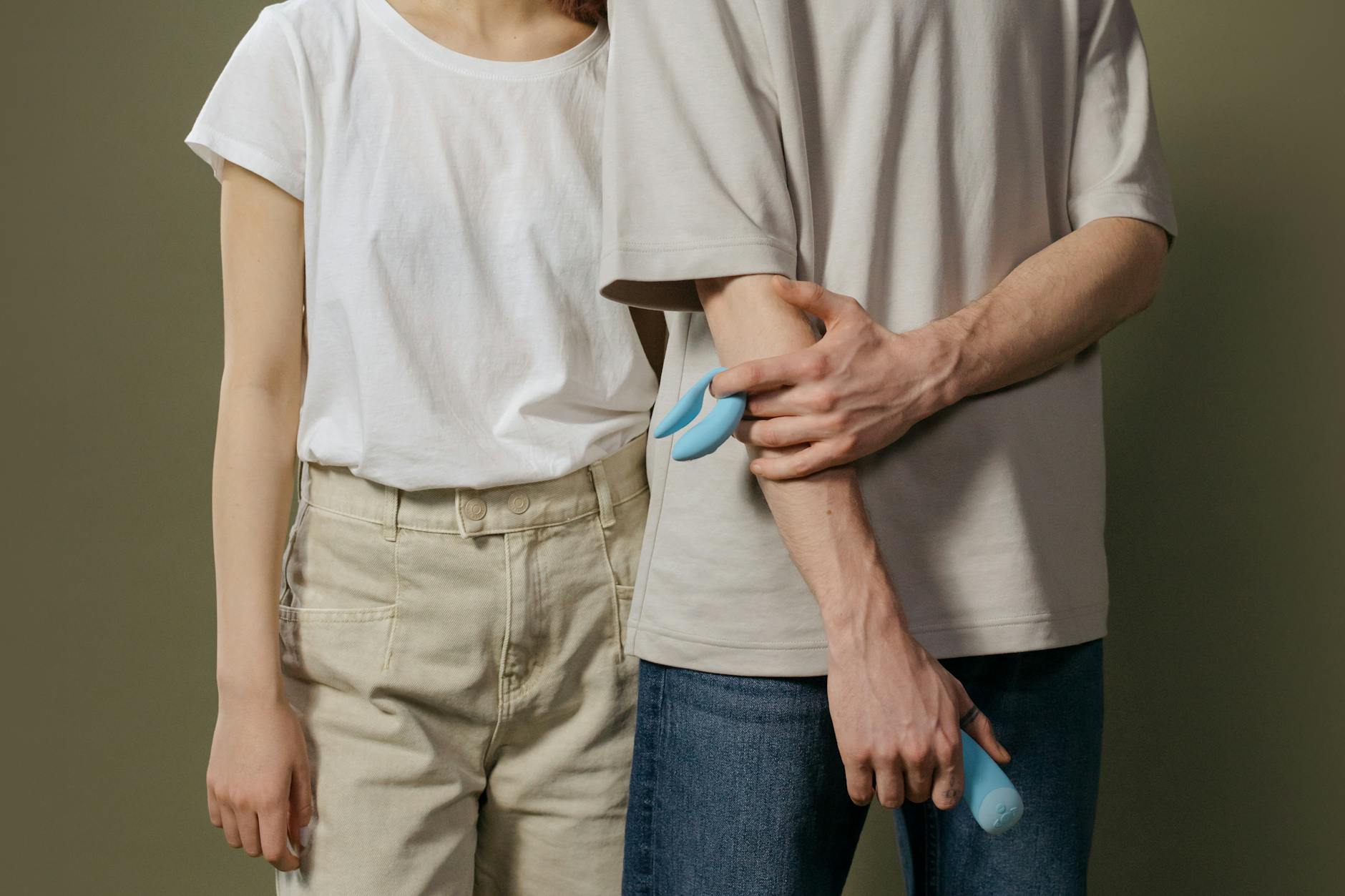 A couple standing close together, holding a vibrator, representing renewed intimacy and reconnection after a period of low desire.
