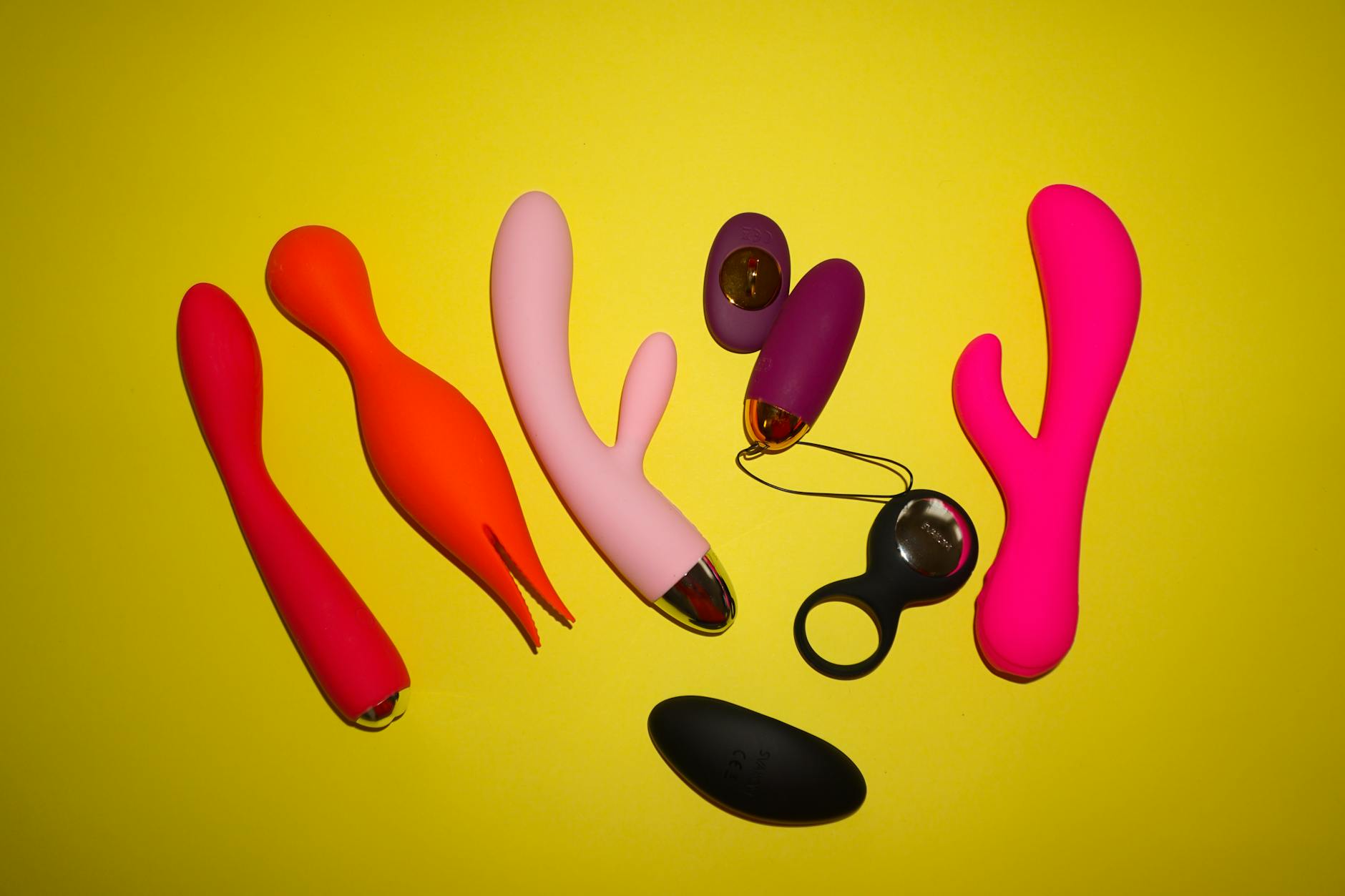 Colorful arrangement of vibrators on a bright yellow background, showcasing design diversity
